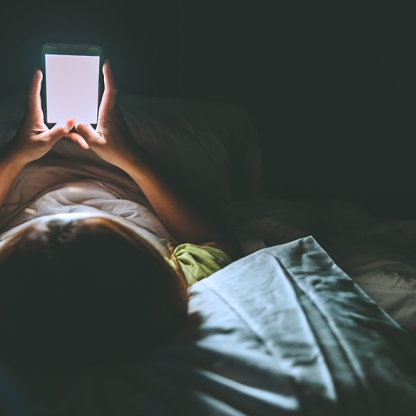 Person looking at mobile device in bed