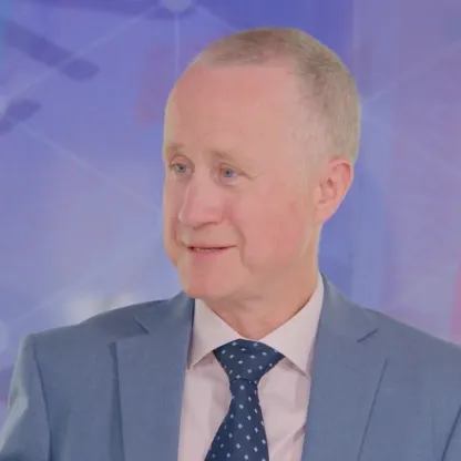 screengrab of Carl Stick wearing blue suit talking in television studio